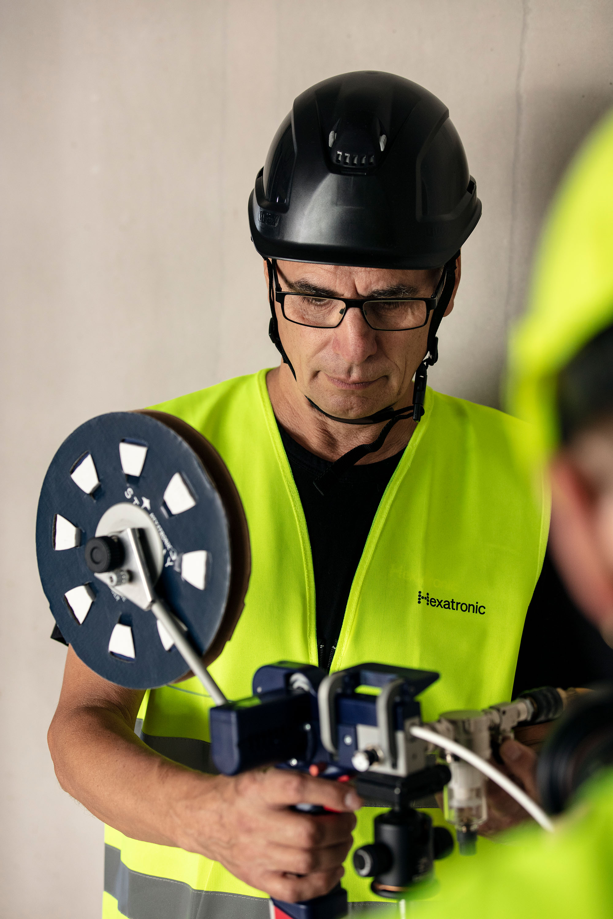 A worker in safety gear, marked ”Hexatronic