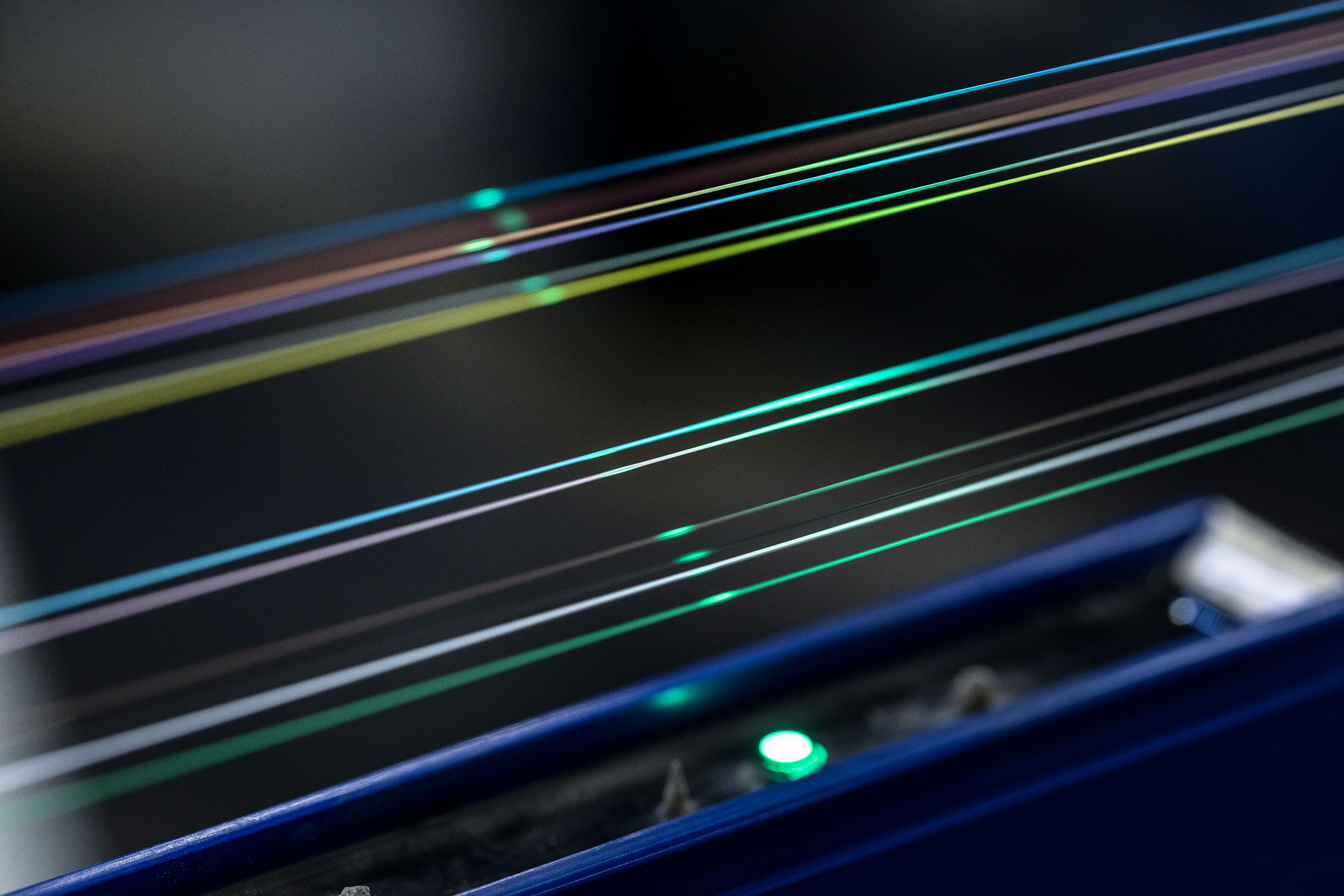 Close-up of vibrant, illuminated fiber optiv wires glowing in different colors against a dark background.